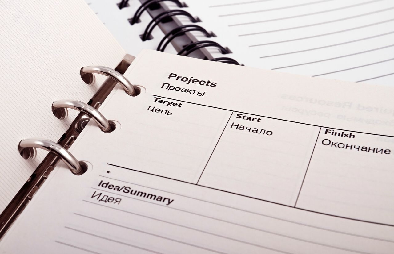 Open planner displaying project schedule with Russian-English text, ideal for office or educational content.